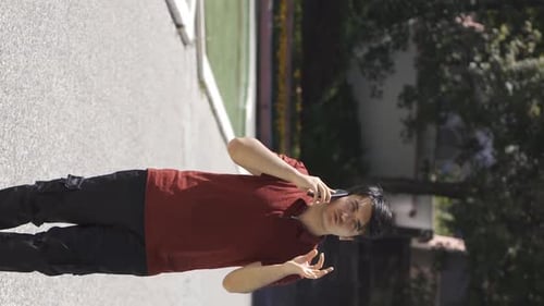 Young Adult Talking on Smartphone Outside on Sunny Day