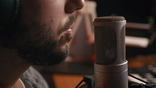 Lower Face of Young Male Podcaster Speaking into Microphone in Studio