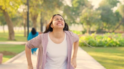 Woman Experiences Pain While Jogging in Park