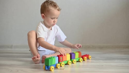 Young Boy Playing with a Colorful Toy Train