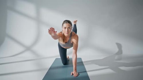 Woman Doing Yoga on a Mat Indoors