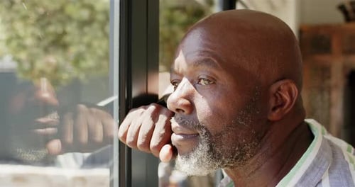 Pensive Man Looking Out Sunny Window