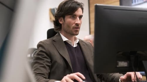 Focused Young Businessman Using Desktop PC in Creative Office