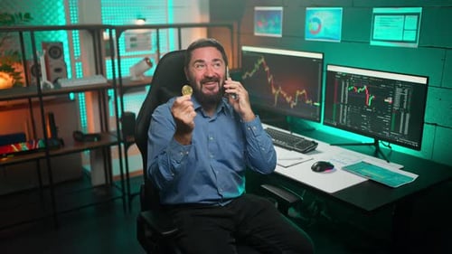 Man Talking on Phone Holding Cryptocurrency Coin