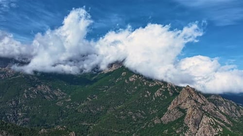 Clouds drift over breathtaking mountain landscape in the afternoon sunlight