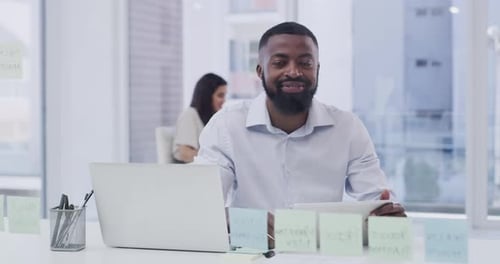 Man Smiling in Modern Workplace with Technology