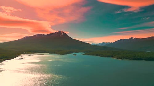 Aerial View of a Serene Lake Surrounded By Mountains at Sunset with Vibrant Sky Colors Reflecting on