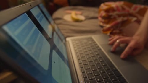 Woman Hands Using Laptop Trackpad on Bed Indoors