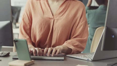 Woman Typing at Desk in Modern Office