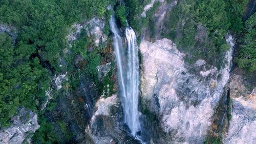 Vue aérienne : cascade de montagne tombant dans la nature verdoyante du paysage forestier