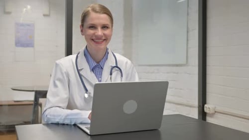Young Doctor Smiling at Camera in Clinic