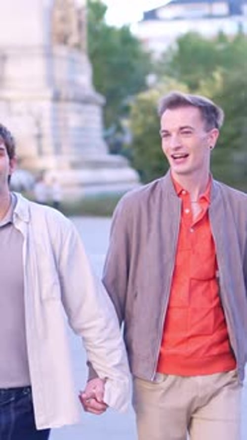 Happy Gay Couple Holding Hands Walking in the Park