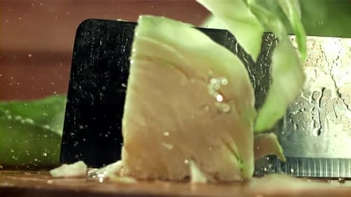 Iceberg Lettuce Being Sliced on a Cutting Board