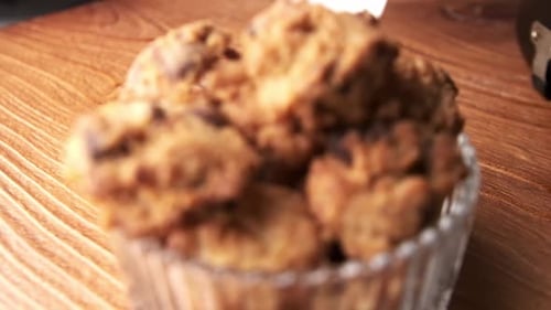 Dolly out close up of chocolate chip cookies on table, slow motion