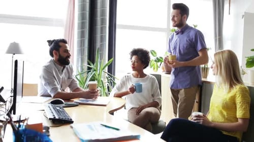 Happy multiethnic business team at coffee break having discussion in modern office