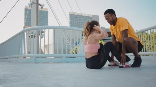 Young Adults Exercising Doing Sit-Ups on Bridge