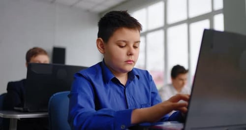 Porträt eines Teenagers, der im Klassenzimmer mit Laptop arbeitet und Codieren und Programmieren lernt
