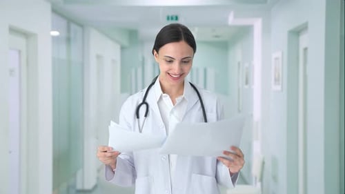Happy Indian female doctor checking medical reports