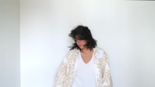 Irradiando positividade, uma mulher se move alegremente em um ritmo invisível. Seu espírito despreocupado é exibido em um