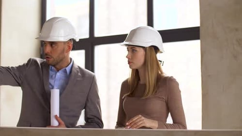 Architects Discussing Project Plans in Unfinished Building