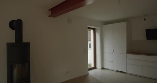 Wide shot of a renovated midcentury house, modern feeling, steel beam separating kitchen and living