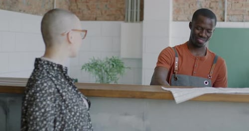 Barista Serving Coffee to Cheerful Customer at Counter