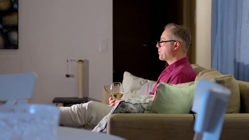 Adult Relaxing on Couch With Wine