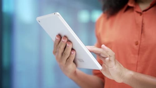 Close up of female hands holding using digital tablet in business office. African american