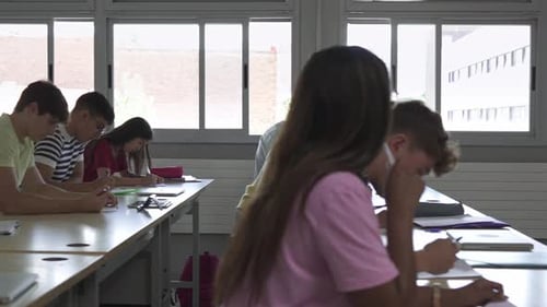 Diverse Students Taking Test in Classroom with Teacher