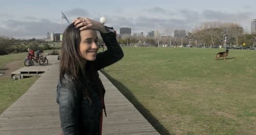 Woman Walking in Urban Park on Sunny Day