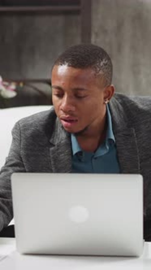 Young Adult Using Laptop at Desk in Office