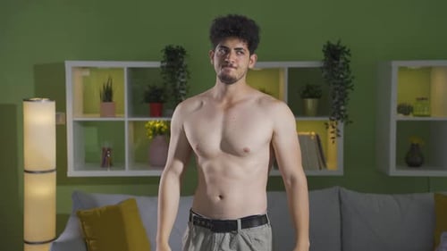 Shirtless Man Flexing Muscles Indoors