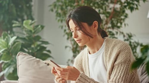 Woman Using Smartphone in Cozy Home Interior