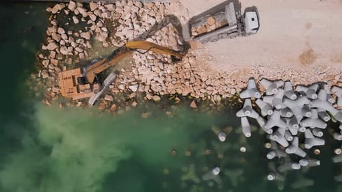 An Excavator Diligently Constructs a Dock or Breakwater in the Sea Its Mighty Arm Reaching Out From