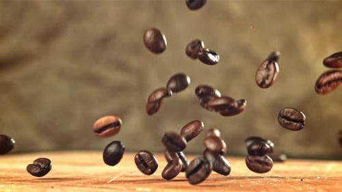 Kaffeebohnen fallen auf ein Holzbrett, gefilmt mit einer Hochgeschwindigkeitskamera mit 1000 Bildern pro Sekunde