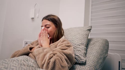 un patient malade hospitalisé est allongé sur un lit, éternue et souffre d'un écoulement nasal, d'une toux