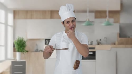 Chef Tasting with Wooden Spoon in Modern Kitchen