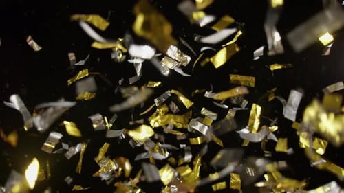 Gold and Silver Confetti Falling Against Black