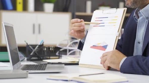 Adult Explaining Data Charts in Professional Office