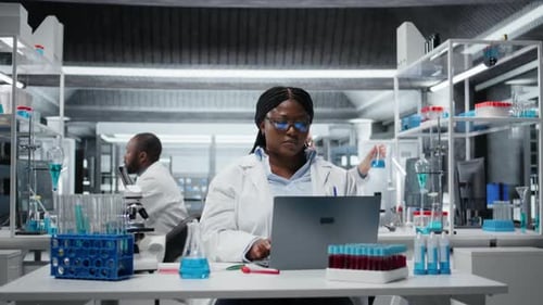 Scientist Working on Laptop in Modern Lab