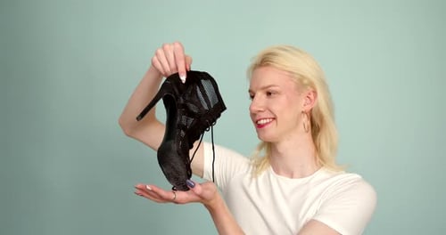 Gay Millennial Young Man Holding in His Hand Black High Heels
