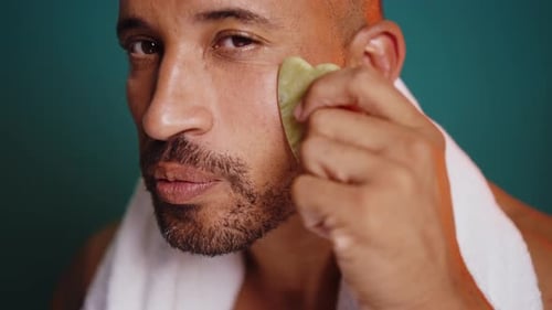 Man Uses Gua Sha Facial Tool for Skincare
