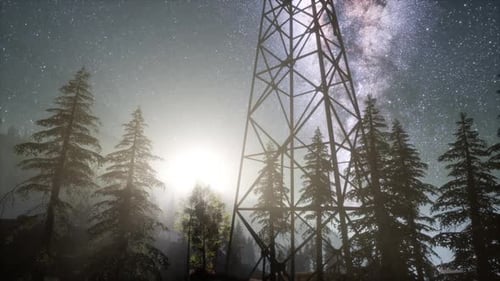 Milky Way and Stars Over Power Line Tower and Pine Forest