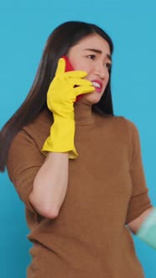 Woman with Smartphone and Cleaning Supplies