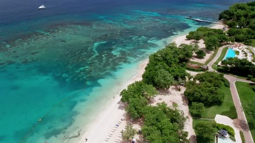 Aerial drone view of holidays beach resort. View of the empty beach and the vibrant turquoise ocean.