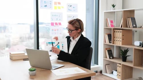Professional Woman Presenting Data Analysis During Virtual Meeting in Office