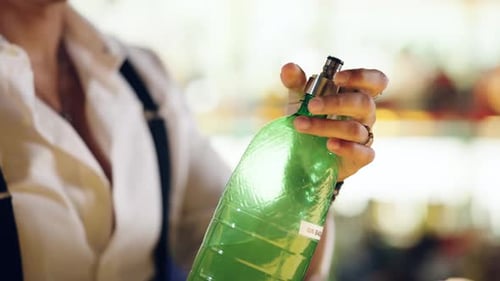Bartender Opening a Green Glass Bottle of Gin
