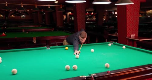 Man Playing Billiards in a Hall at Night