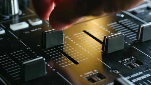 DJ mixer board being adjusted, music production