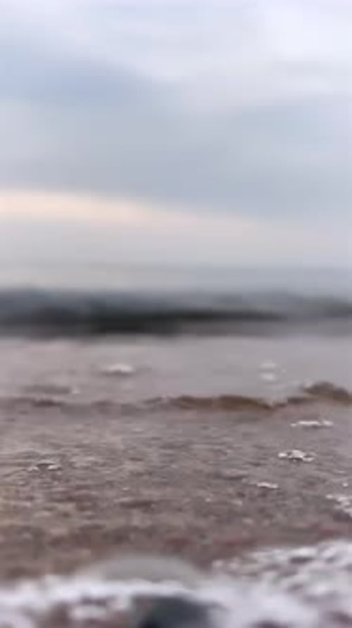 Serene Shoreline with Textured Sand and Foamy Surf Calm Beach Landscape Emphasizing Detail in Sand